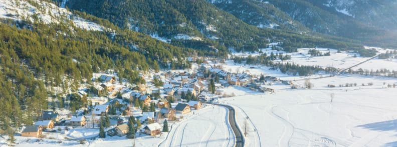 Skiing in France Montgenevre Alpine Village Winter Aerial view of Montgenevre village surrounded by snowy fields and forested slopes in the Southern Alps.