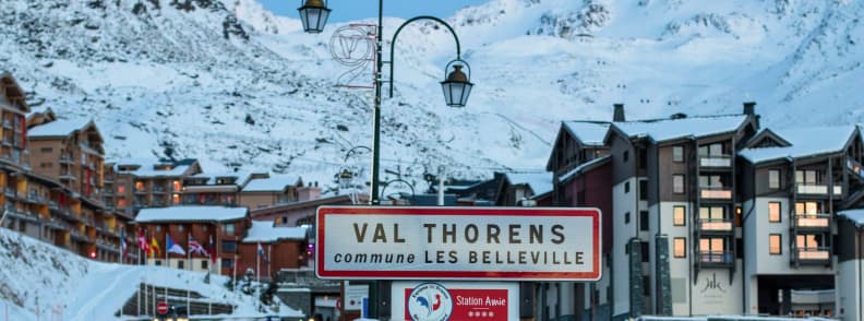 Where to Stay in Val Thorens Hotels for Every Budget Entrance sign to Val Thorens with snow covered buildings and mountains in the background.