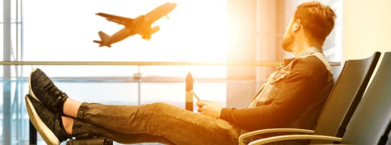 man in airport with carry on bag