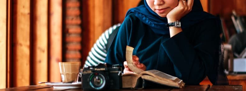 solo female traveler reading while waiting to dine alone