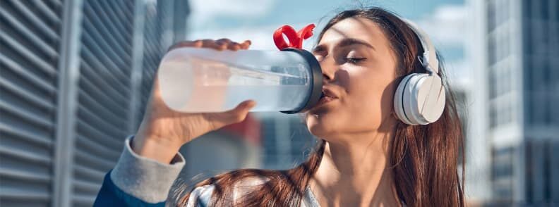 woman drinking water hydrated while traveling