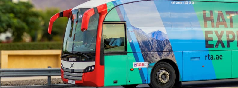 Dubai to Hatta Express bus service Hatta road trip transport Hatta Express RTA bus traveling from Dubai to Hatta with mountain backdrop