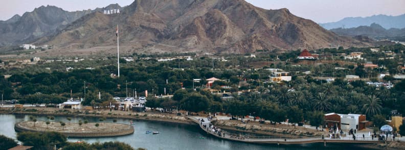 Hatta Hill Park picnic BBQ and family viewpoint in UAE Aerial view of Hatta Hill Park with lake, greenery, and mountains in the background