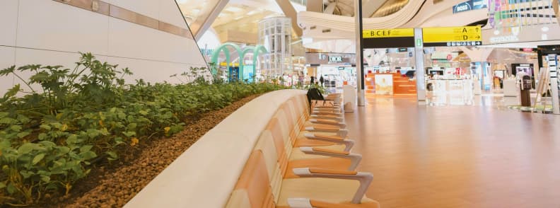 Cheap flights Abu Dhabi airport budget travel Interior of Abu Dhabi International Airport with seating area and duty free shops