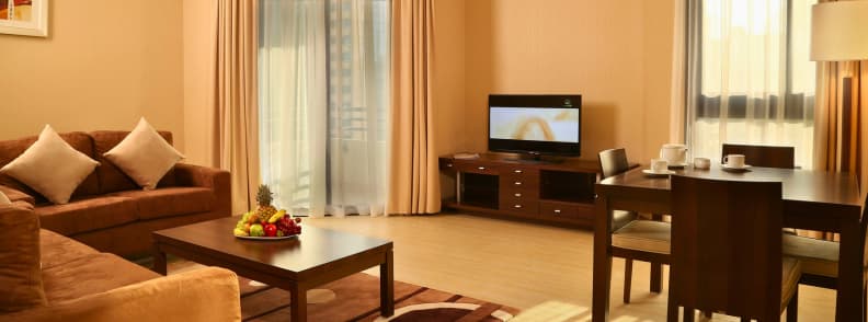 Cheap hotels Abu Dhabi budget accommodation options Interior of a budget hotel apartment in Abu Dhabi with sofa dining table and television