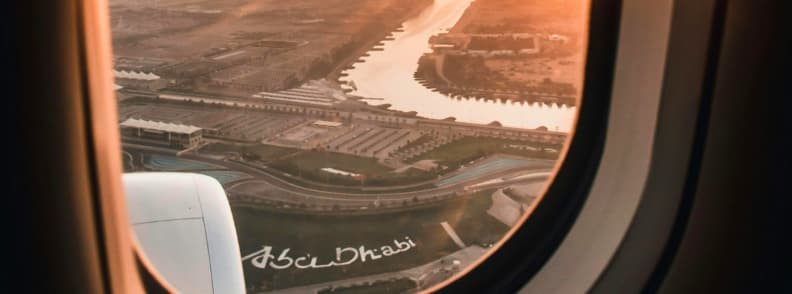 Aerial view of Abu Dhabi city and coastline at sunset seen from airplane window