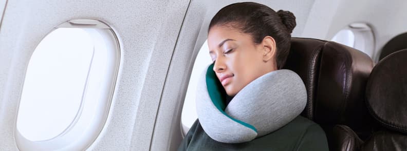 OstrichPillow Go Neck Review Best Airplane Pillow for Long Flights Passenger resting with the OstrichPillow Go Neck memory foam travel pillow on an airplane seat, reviewed as one of the best travel pillows for comfort and neck support on long flights.