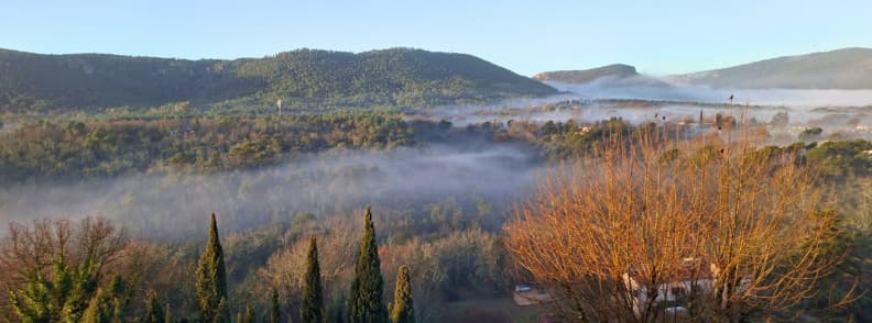 Bagnols en Foret autumn valley view in Provence Var Autumn view over the valley below Bagnols-en-Forêt, with low morning mist, cypress trees, golden foliage, and forested hills in the Var.