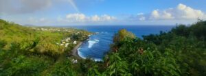 Scenic coastal view of La Réunion near Saint-Philippe with rainbow, ideal for first-time visitors to La Réunion, featuring black sand beaches and lush coastline