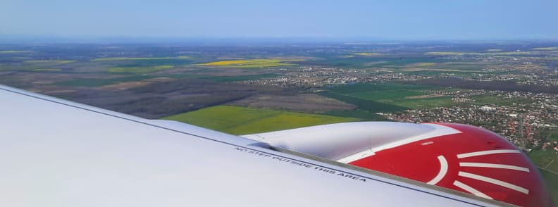 View over Romania during descent on Animawings Airbus A220-300 flight from Nice to Bucharest, with engine and wing visible