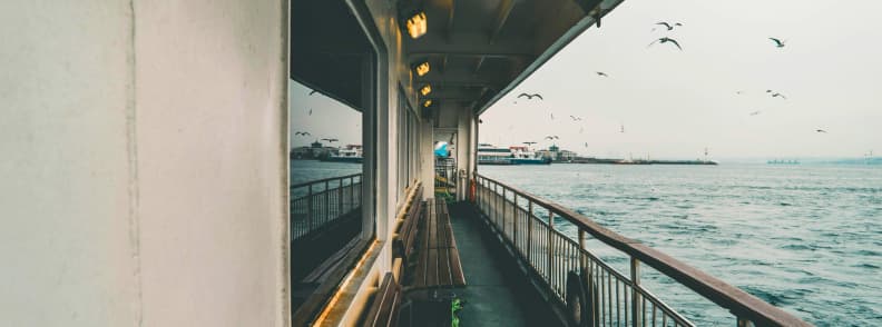 Ferry Travel With Baby Open Deck and Coastal Views View of a peaceful ferry deck with empty benches and seagulls in the air. Ideal setting for ferry travel baby adventures