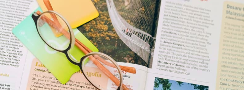 Planning and Saving Budgeting Tips for Traveling With a Baby Glasses and notes on a travel guide, symbolizing research and planning for baby travel budget and family travel savings