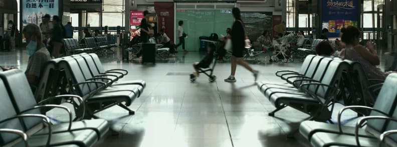gate check stroller on airplane A parent pushes a toddler in a lightweight stroller through an airport terminal, illustrating how to gate check a stroller when flying with toddlers