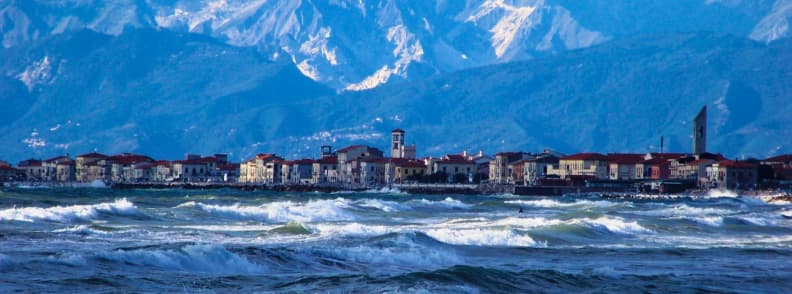 marina di pisa Italian sailing marinas Pisa Choppy sea conditions at Marina di Pisa, Italy, with waves breaking near the shore and the Apuan Alps rising in the background, a reminder of why many sailors choose protected Italian sailing marinas Pisa offers upriver.