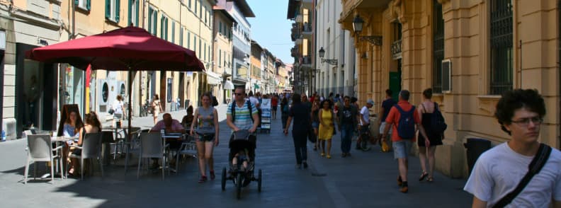 pisa italy travel guide with kids People walking and dining on Corso Italia Pisa, a family-friendly pedestrian shopping street in summer