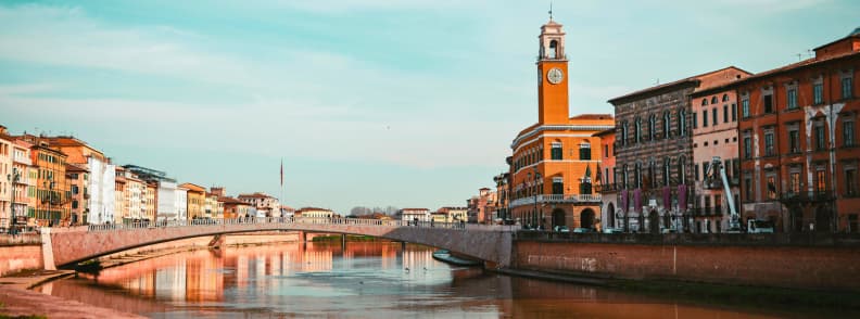 river arno ponte di mezzo pisa photo guide Ponte di Mezzo bridge over the River Arno Pisa with historic buildings and clock tower in evening light