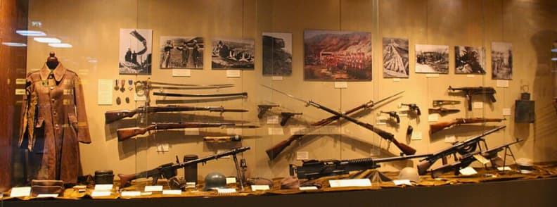 Display of weapons, uniforms, and photographs at the Hellenic War Museum in Athens