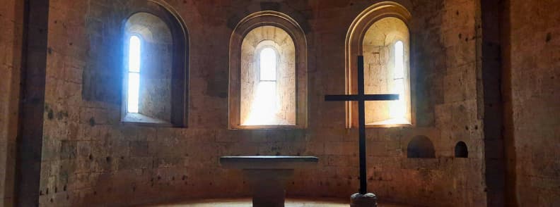 Altar and Apse Thoronet Abbey Cistercian Church Provence Stone altar and wooden cross in the apse of Abbaye du Thoronet church in Provence, lit by three tall arched windows