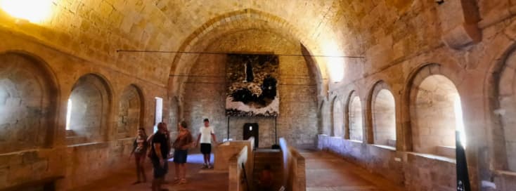 Events at Abbaye du Thoronet Concerts Exhibitions and Heritage Days Visitors exploring an exhibition inside the historic dormitory of Abbaye du Thoronet during a cultural event