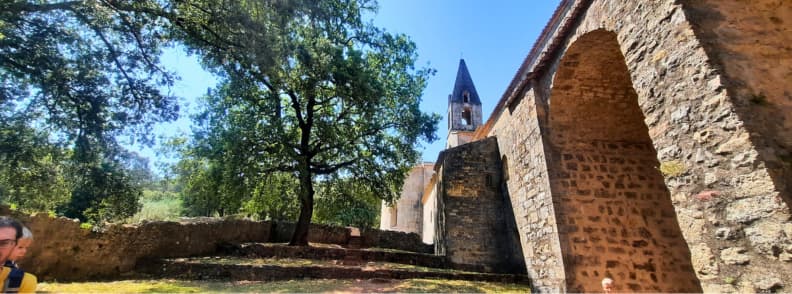 Exterior Walls of Abbaye du Thoronet Medieval Cistercian Provence Stone exterior walls and bell tower of Abbaye du Thoronet in Provence, surrounded by oak trees on a sunny day