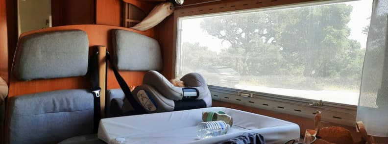Family Camper Travel to Carces Road Trip in Provence Verte Toddler car seat in a camper interior during a family road trip to Carcès in Provence Verte