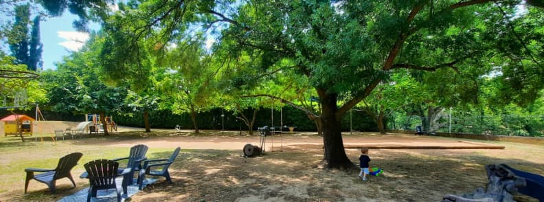 Family Friendly Playground at Camping Fouguieres in Carces Shaded playground with swings, slide, and pétanque court at Camping Fouguières in Carcès
