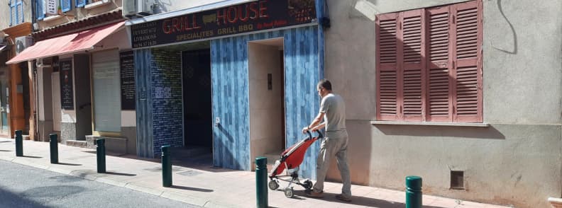 Family Friendly Walk Through Carces Exploring Provence Verte with Kids Man pushing a stroller along Rue Maréchal Foch in Carcès near local restaurants