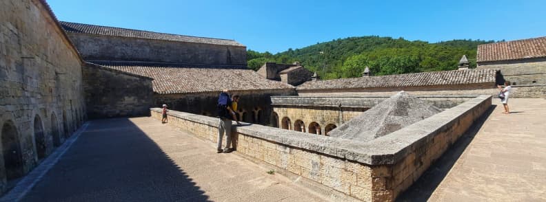 Family Visit to Abbaye du Thoronet Cloister Terrace View Provence Parent carrying a toddler on the cloister terrace of Abbaye du Thoronet with surrounding Provençal hills in the background