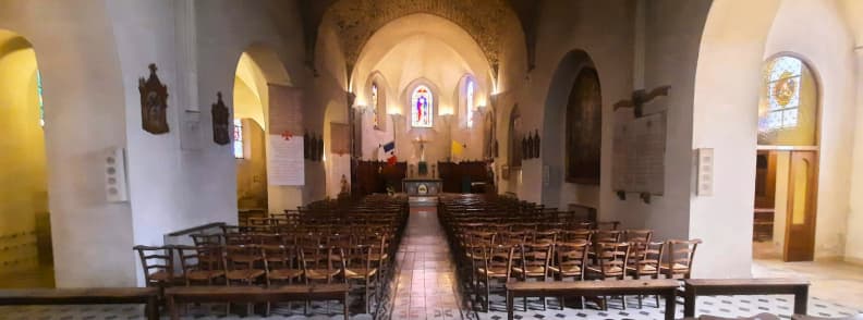 Interior of Eglise Sainte Marguerite in Carces Historic Church in Provence Verte Interior of Église Sainte-Marguerite in Carcès with rows of wooden chairs and stained-glass windows