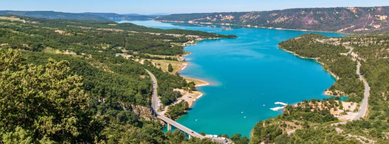 Lac de Sainte Croix Gateway to the Verdon Gorges in Provence Aerial view of Lac de Sainte-Croix with turquoise water, surrounding hills, and a bridge leading to the Verdon Gorges