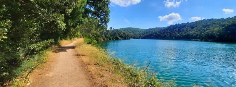 Lakeside Trail at Lac de Carces Scenic Walk in Provence Verte Dirt trail along the shore of Lac de Carcès with turquoise water and forested hills in Provence Verte