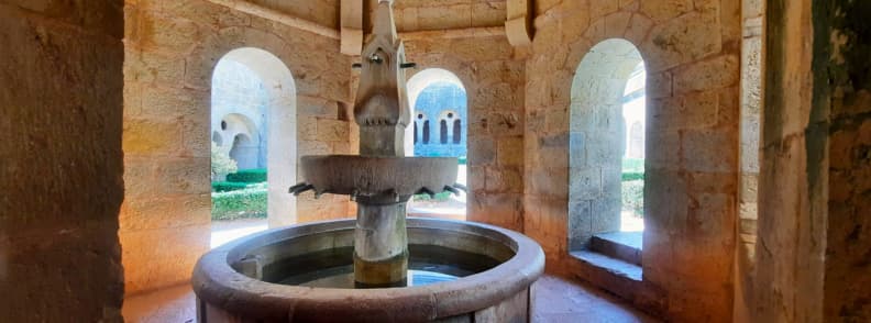 Lavabo of Le Thoronet Monastery Cistercian Thoronet Abbey Provence Lavabo monastique inside Abbaye du Thoronet in Provence, a stone fountain used by medieval monks for ritual washing, surrounded by Romanesque arches in the cloister