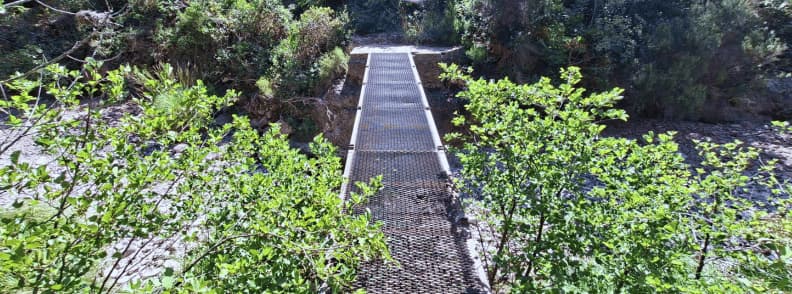 Metal bridge crossing Ravin du Gratadis Esterel Massif Saint Raphael Metal footbridge without railings over the stream on the Ravin du Gratadis trail near Col de Belle Barbe in the Estérel Massif en route to Col d'Aubert