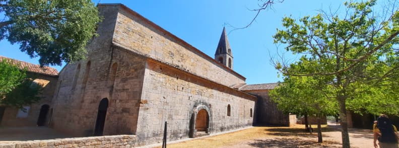 Thoronet Abbey Highlights Iconic Cistercian Site in Provence Exterior view of Abbaye du Thoronet in Provence with its Romanesque stone walls and bell tower framed by trees