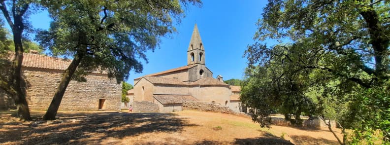 Visit Abbaye du Thoronet in Provence. Thotonet Abbey Cistercian monastery surrounded by oak trees on a sunny summer day