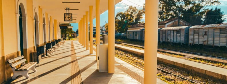 Athens train station platform with benches and clock showing Greek railway infrastructure and suburban rail connections