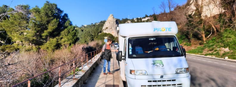 Camper van parked on the roadside near Les Baux-de-Provence with the medieval fortress visible in the distance