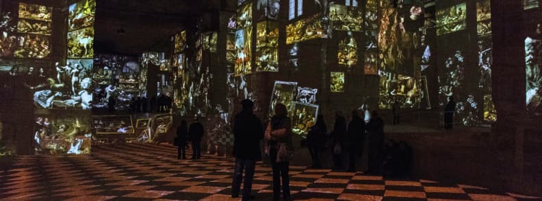 Visitors watching immersive digital art projections inside the Carrières de Lumières quarry at Les Baux-de-Provence