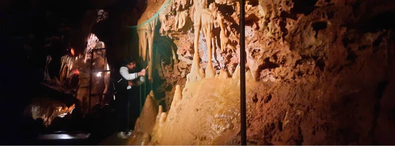 Saint Cezaire cave guide musical stalactites demo Guide demonstrating musical stalactites inside Saint Cezaire cave during a guided tour