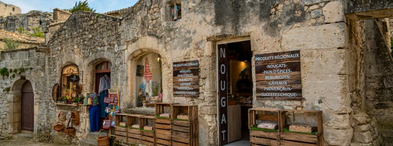 Stone façade of an artisan shop in Les Baux-de-Provence selling nougat, gingerbread, Provençal sweets, and local crafts