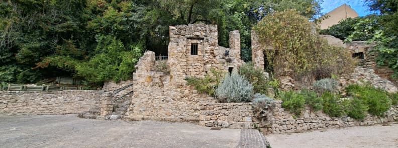 Theatre du Rocher Cotignac Open Air Theatre Provence Stone ruins of the open-air Théâtre du Rocher in Cotignac France surrounded by trees beneath the village cliff.
