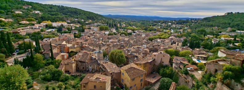 Things to do in Cotignac Village View from Le Rocher Provence Panoramic view of Cotignac France from the Rocher cliff showing terracotta rooftops, winding lanes, and the green hills of Provence Verte.