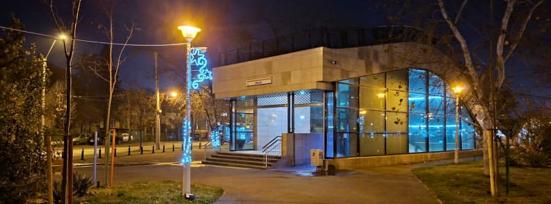 Eroilor metro entrance at night with blue Christmas lights in Bucharest near key Christmas transport routes.