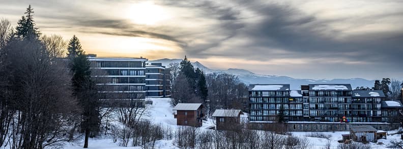 Budget winter trip to Europe. Snow covered European mountain town with hotels and apartments during winter travel season