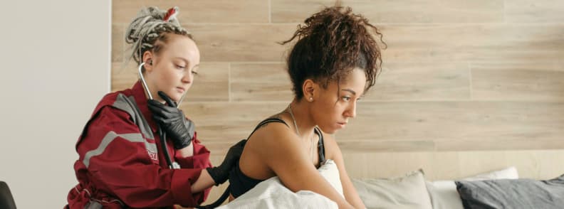 holiday donation ideas emergency medical aid support healthcare worker providing medical assistance to a woman during a home visit supported by humanitarian aid donations