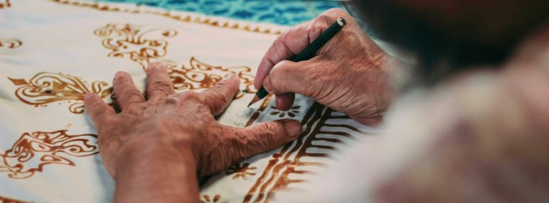 holiday donation ideas supporting local artisans artisan hands creating traditional textile patterns as part of a community craft program supported by donations