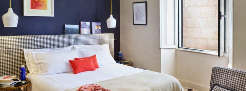 Stylish boutique hotel room in Rome with houndstooth headboard and open window