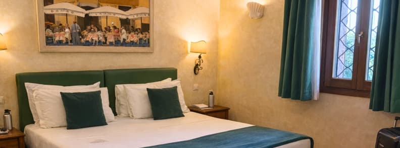 Classic budget hotel room in Trastevere with green accents and double bed