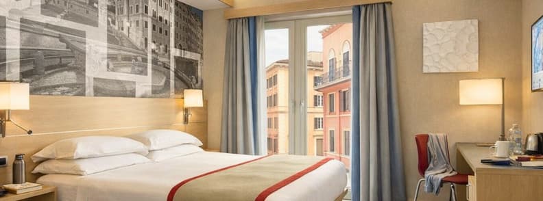 Modern budget hotel room in Rome with balcony and city view near the Opera