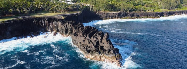 Cap Mechant basalt cliffs on Reunion East Coast with waves crashing against volcanic rock